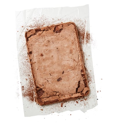 Mettez une grande feuille de film alimentaire (vous pouvez aussi utiliser du papier sulfurisé ou un torchon, mais je trouve que le film alimentaire est plus facile ici) sur un plan de travail et saupoudrez le tout de cacao en poudre. Retournez délicatement la meringue dessus, longs côtés parallèles aux longs côtés du film alimentaire, puis retournez-la de manière à ce que l'un des petits côtés soit face à vous. Faites une petite entaille sur toute la largeur de la meringue, à environ 2 cm de l'extrémité la plus proche de vous.
