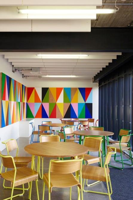 Colourful walls and wooden chairs around circular wooden tables