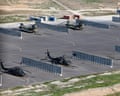 Military helicopters sit on the tarmac at a military base.