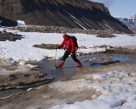 Dr Arwyn Edwards steps over a melt channel beneath a Svalbard glacier.