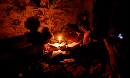 Palestinian children do their homework during a power cut in Gaza City