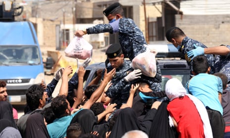  Iraqi security forces distribute food to people in need during curfew due to coronavirus pandemic in Baghdad