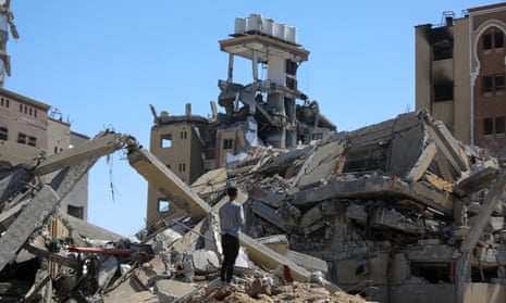 People collect usable items from the rubble of damaged buildings in al-Zahra district of Gaza City.