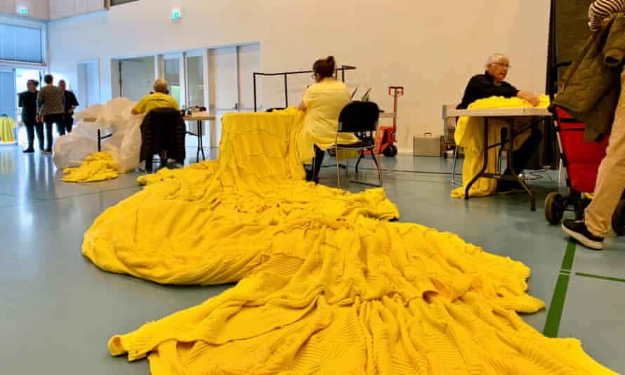 Residents of local hospices and care homes used 9,000 balls of yarn to knit a giant 600kg yellow jersey to be hoisted at the port.