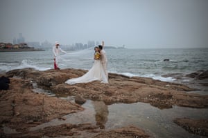 A couple pose for their pre-wedding photos in front of the Yellow Sea, in Qingdao