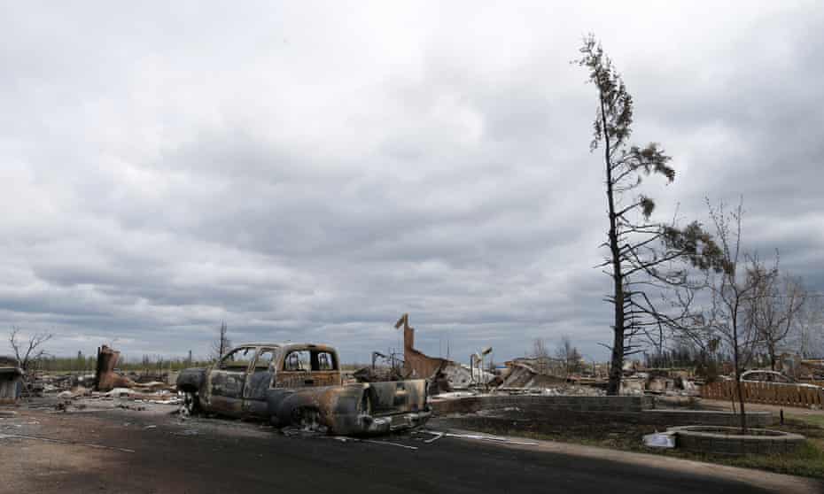 A charred vehicle and homes are pictured in the Beacon Hill neighbourhood of Fort McMurray, Alberta, Canada, May 9, 2016 after wildfires forced the evacuation of the town.