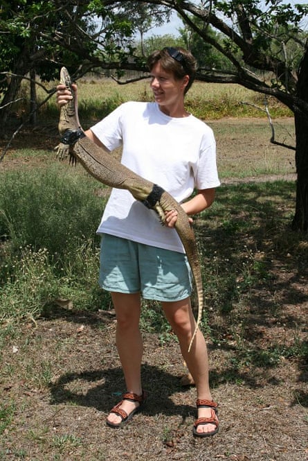 Beata Ujvari holds a goanna that has been restrained with tape.