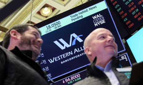 A screen displays that trading is halted for Western Alliance on the floor of the New York Stock Exchange