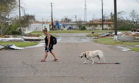 A local resident and her dog walk home in Houston in the aftermath of Hurricane Harvey, the strongest to hit the US since 2005. 