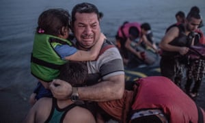 Laith Majid, a Syrian refugee, holding his son and daughter, arriving on the Greek island of Kos in August.