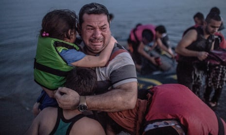 Laith Majid, a Syrian refugee, holding his son and daughter, arriving on the Greek island of Kos in August.