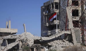 The Syrian national flag flies in Deraa after troops loyal to Bashar al-Assad entered the city.