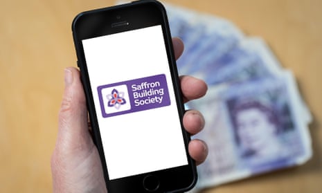 A woman holding a mobile phone showing Saffron Building Society