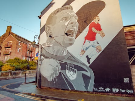 A mural of a footballer on the end wall of a building