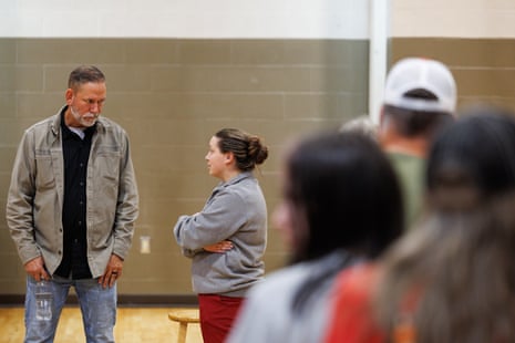 Dan Osborn converses with an attendee after a town hall, with blurred people in the foreground