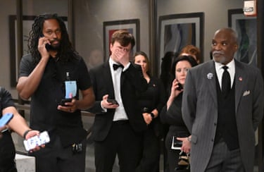 Attendees check their phones in the lobby of the Washington Hilton after shots were heard during the White House Correspondents’ Dinner.