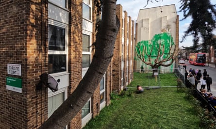 Accentuating reality … crowds are flocking to Banksy’s cherry tree mural.