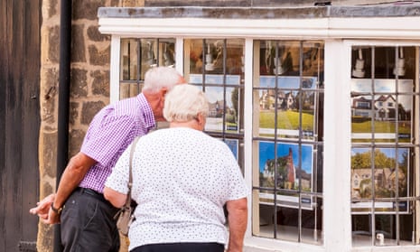 An elderly couple looking in an Estate Agents window