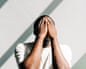 African American man tired and stressed, covered his face with his hands. Mental health, prevention of burnout and depression.