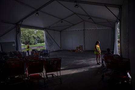 People are waiting under the food cart tent.