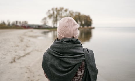 Rear,View,Of,A,Woman,In,Beanie,And,Warm,GreyRear view of a woman in beanie and warm grey woollen scarf on a beach in winter standing staring out over the calm ocean on a cold bleak day; Shutterstock ID 2085871954; purchase_order: -; job: -; client: -; other: -