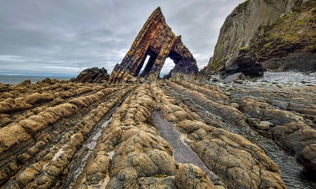 Patterned rock formation with rock arch by the sea