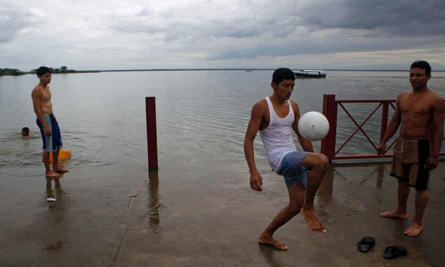 Men play with a football on the San Juan riverside in San Carlos, Nicaragua.