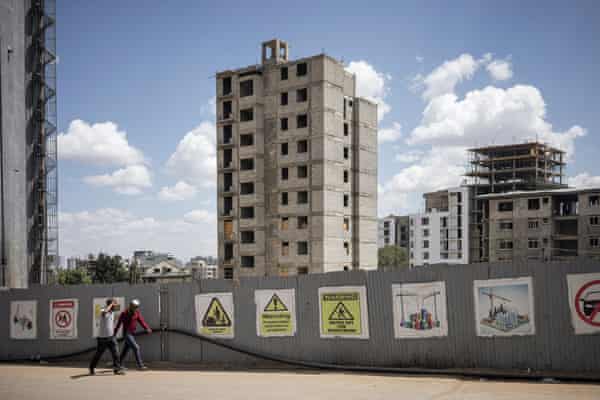People walk past a construction site and unfinished building in the historical Piazza neighbourhood of Addis Ababa