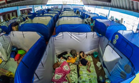 Families take shelter inside emergency tents at an evacuation centre in Marikina.