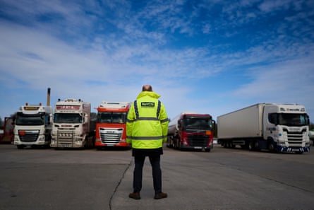 Mike Dawber from behind, looking at several lorries parked in front of him