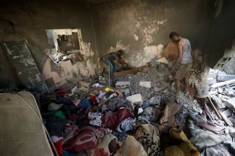 Palestinians look for their belongiongs at the site of an Israeli strike.