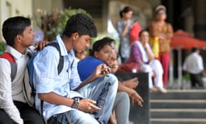 A pedestrian accesses the internet on his mobile phone in Bangalore