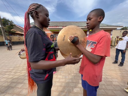 Florence Lugemwa encourages a boy playing cymbals.