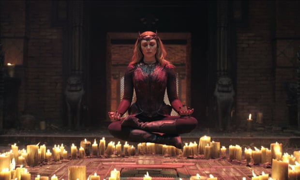 Scarlet Witch sits behind a circle of candles