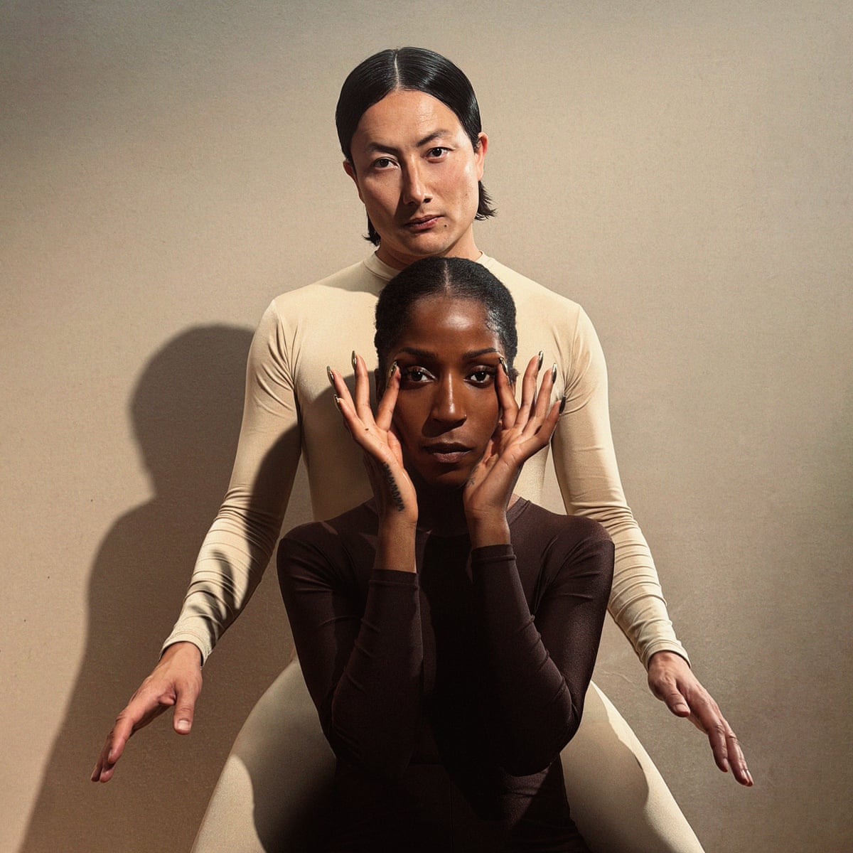Two musicians, one in a bodysuit, the other in black