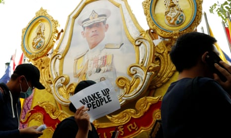 Pro-democracy protesters walk past a picture of King Maha Vajiralongkorn during a rally in Bangkok in August 2020