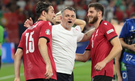 The Georgia coach, Willy Sagnol, celebrates their win against Portugal with Giorgi Gvelesiani and Lasha Dvali.