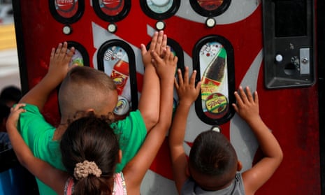 children play with a soda dispenser in mexico