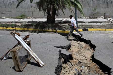 A man walks in a cracked street.