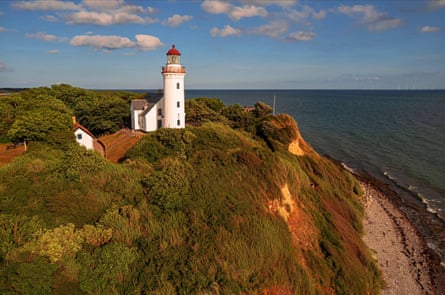 Lighthouse set on a cliff against blue skies