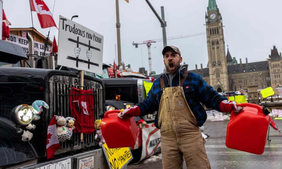 A protester bangs gas cans together while yelling ‘Freedom’ in Ottawa on Thursday.