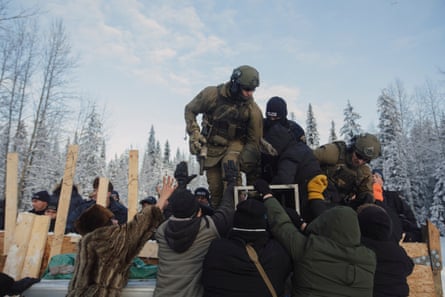Police climb over a barricade to enforce the injunction filed by Coastal Gaslink Pipeline at the Gidimt’en checkpoint near Houston, British Columbia on Monday, January 7, 2019. The pipeline company were given a permit but the Office of the Wet’suwet’en, who have jurisdiction over the territory in question, have never given consent. Fourteen people were arrested. Amber Bracken for The New York Times