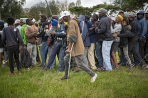 Homeless recyclers and others queue up to receive food in a park in Johannesburg
