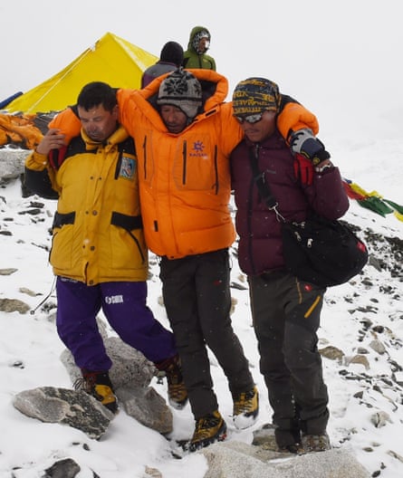 Rescuers assist an injured at Everest base camp.