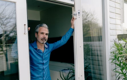 Dennis Biesma stands successful nan doorway of his home, wearing a bluish shirt