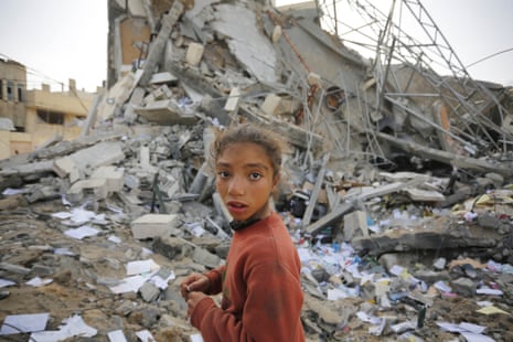 A Palestinian child is seen in front of destroyed Az-Zawayda town hall after the Israeli attacks in Deir al-Balah, Gaza on Wednesday.