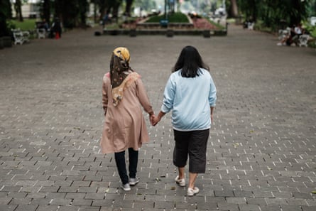 Two women holding hands seen from behind