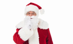 santa claus gesturing for silence and looking at camera