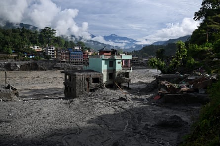 A turquoise-green house stands tall amid sludge near Trishuli River in the aftermath of flash floods at the Trishuli Centre in Nepal’s Nuwakot district on Wednesday