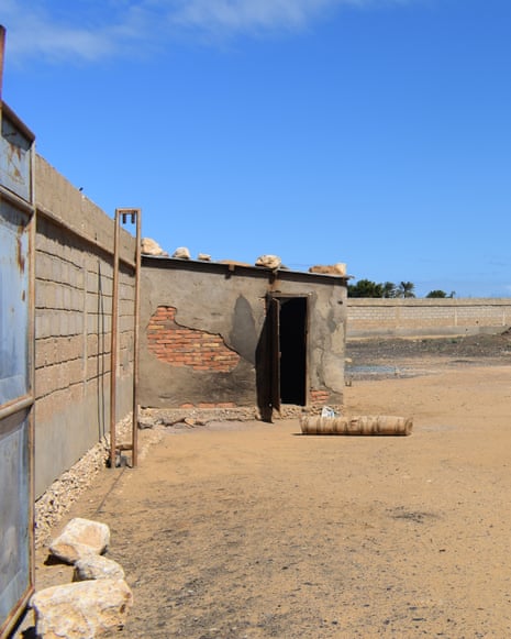 A rudimentary brick hut with a missing door against a blue sky